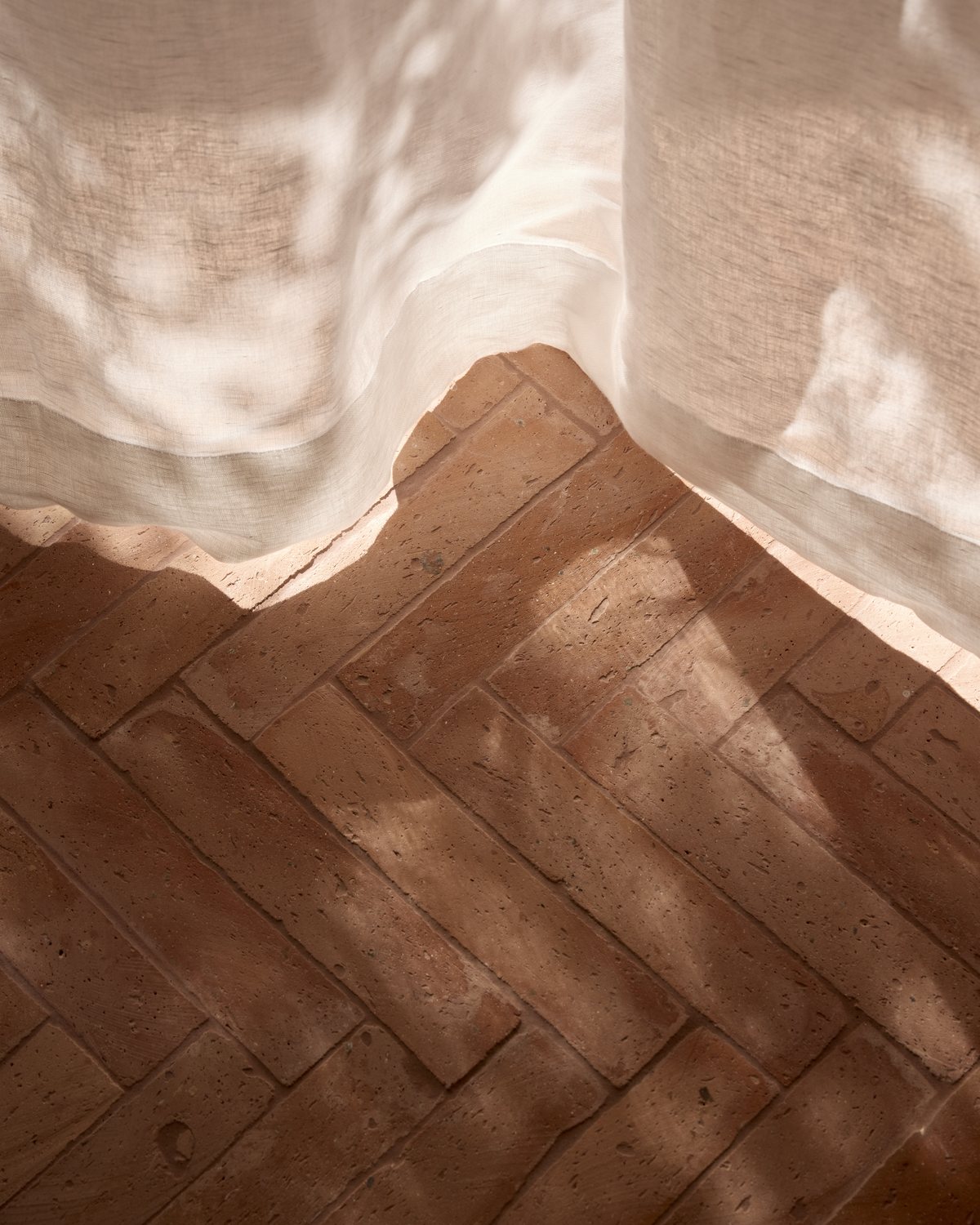 Linen curtain over a terracotta floor, Paddington Residence